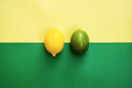 Top view of colorful yellow and green lemons on yellow green pastel background, concepts,summer ideas of fruit, vegetable, healthy eating lifestyleの写真素材
