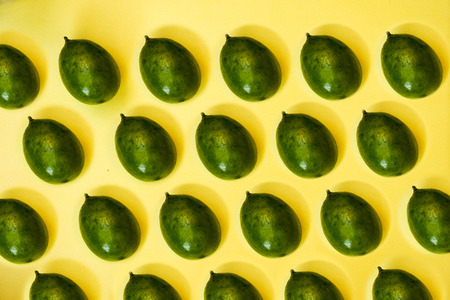 green lemons on yellow pastel background, concepts,summer ideas of fruit, vegetable, healthy eating...
