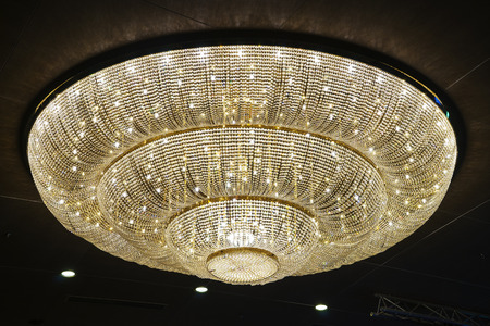 Close-up of beautiful crystal chandelier round shape hanging from the ceiling in the interior.