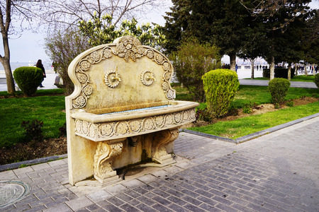 Drinking fountain. An ancient urban drinking fountain in an old marble carved wall. Public mixer for drinking water, dispenser for drinks in public park. Ancient stone fountain waterの写真素材