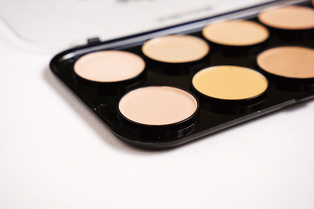 Powder brown color in black powder case which opened and powder puff with ribbon isolated on white backgroundの写真素材