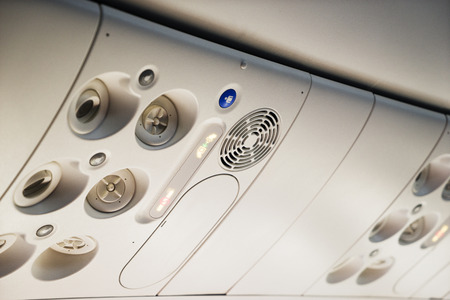 different buttons in the plane on the ceiling in the cabin for passengersの写真素材