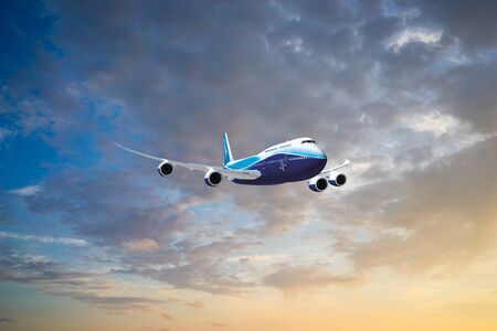 Airplane flying above dramatic clouds during sunset.の写真素材