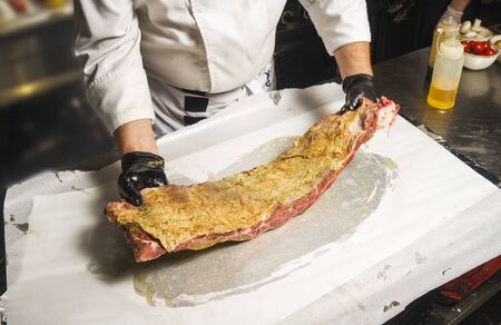 The chef also prepares lamb shank dishes. The process of cooking lamb shank male chef in a professional kitchen. Cooking meat in a Caucasian restaurant.の写真素材