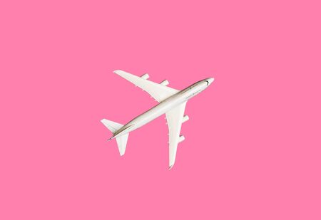 Model plane, airplane on pink pastel color background with copy space.Flat lay design.Travel concept on pink background. top view model plane on pink color backgroundの写真素材
