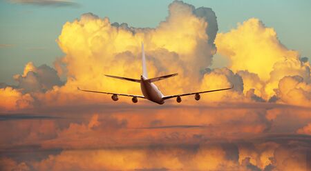 Airplane flying above dramatic clouds during sunset,sunriseの写真素材
