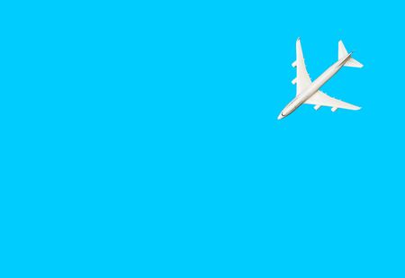 White model of passenger plane on blue background.の写真素材