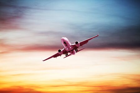 Airplane flying above dramatic clouds during sunset,sunriseの写真素材