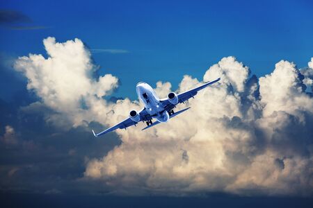 Airplane flying above dramatic clouds during sunset,sunrise