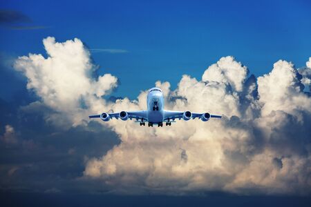 passenger plane in flight. Aircraft fly high in the blue sky over the clouds. Side view of aircraft.