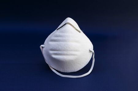 Prevent coronavirus. Medical mask, Medical protective mask isolated on blue background. Disposable surgical face mask cover mouth and nose. Healthcare medical Coronavirus quarantine, hygiene concept.の写真素材