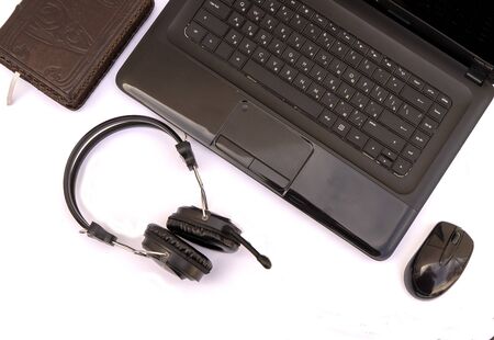 Modern workplace, accessories laptop, headphones, mouse, Notepad on a white background . the view...