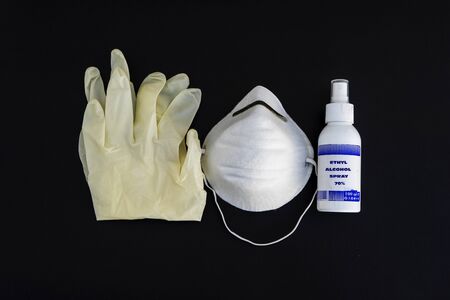 Virus protection. Medical surgical mask, sanitizer gel and lab gloves on black background. Risk...