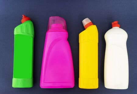 multicolored plastic bottles with household for chemicals on a blue background.
