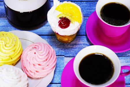 Coffee in red cups and cakes on the blue wooden table. Dessert, Breakfast, sweetsの写真素材