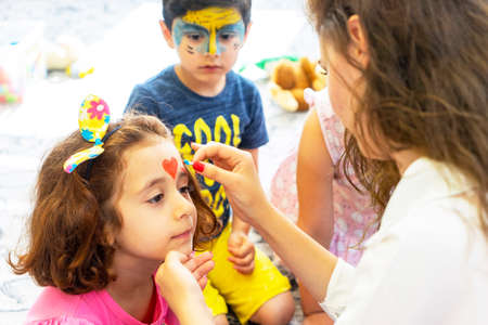 BAKU,AZERBAIJAN- 13 MAY 2019 : Girl draws little girl aqua makeup. Face painting. Children leisure.