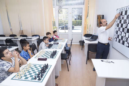 BAKU, AZERBAIJAN-MAY 16, 2019: Children are engaged in a chess school with a teacher.のeditorial素材
