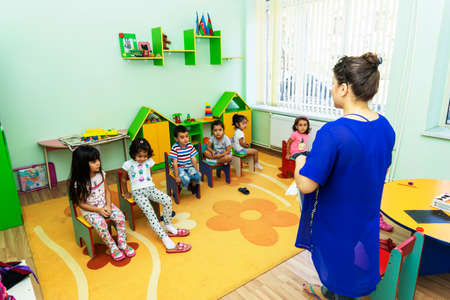 BAKU,AZERBAIJAN-APRIL 17, 2019: children play with toys and engage with the tutor in a kindergarten, schoolのeditorial素材