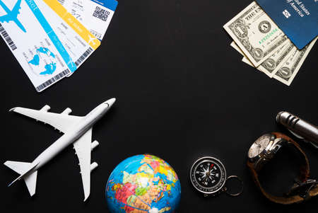 plane, globe, passport, dollars, compass clock magnifierknife on black background travel conceptの写真素材