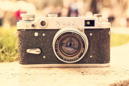Vintage Soviet film camera on a boulder on a blurry background of nature. Shallow depth of field...