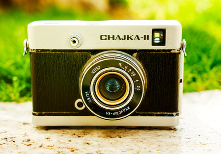 Vintage Soviet film camera on a boulder on a blurry background of nature. Shallow depth of field with focus on the camera. Outdoor. Retro image style.の写真素材