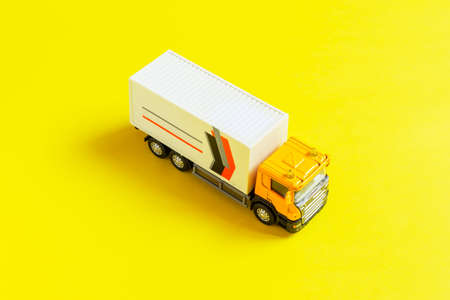 A yellow semi-truck with a white trailer attached isolated on  yellow