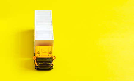 A yellow semi-truck with a white trailer attached isolated on  yellowの写真素材