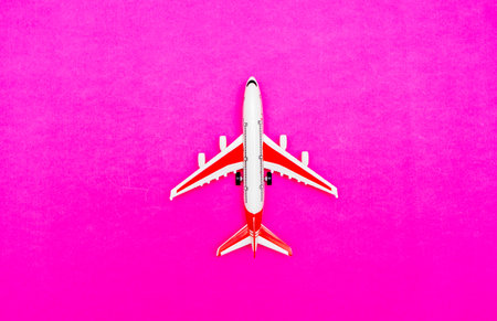 White and red Passenger Model airplane on a red, pink background. Free space for text. Travel conceptの写真素材