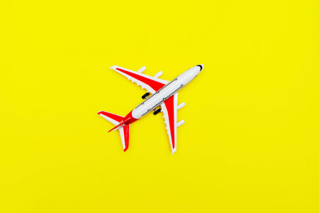 White and red Passenger Model airplane on a yellow background. Free space for text. Travel concept
