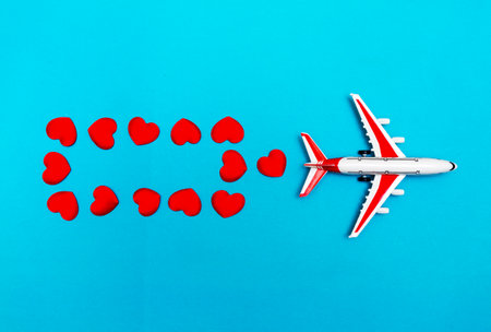 Airplane toy and heart on blue background, love travel conceptの写真素材