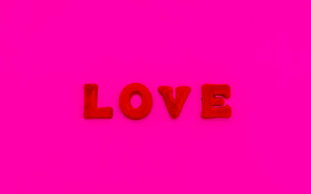 The word Love is made up of red letters on a pink background. Valentine's Day lovers concept.の写真素材