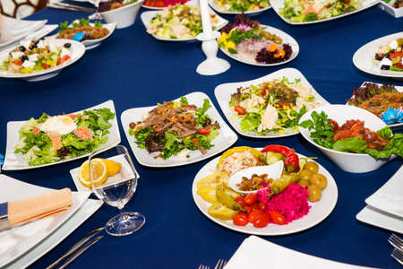 Beautifully decorated catering banquet table with different food snacks and appetizers fresh fruits on corporate event or wedding celebration.の写真素材