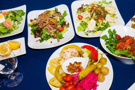 Beautifully decorated catering banquet table with different food snacks and appetizers fresh fruits on corporate event or wedding celebration.の写真素材