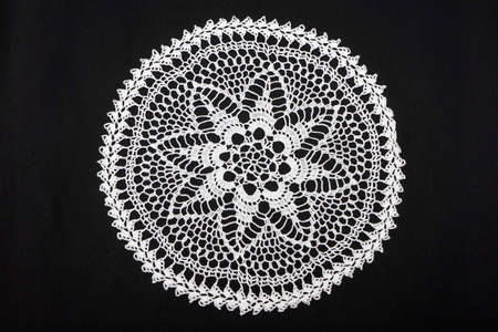 Vintage handmade white knitted napkin isolated on a black backgroundの写真素材