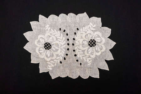 Vintage handmade white knitted napkin isolated on a black backgroundの写真素材