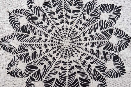 Vintage handmade white knitted napkin isolated on a black background.の写真素材