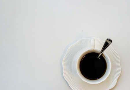 Cup of black hot espresso coffee with steam on white background. Top view, copy space. Morning espresso on table.の写真素材
