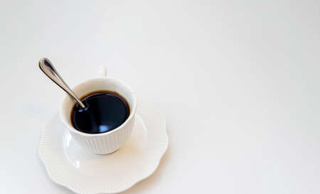 Cup of black hot espresso coffee with steam on white background. Top view, copy space. Morning espresso on table.の写真素材