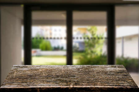 Wooden brown table top against the blurred corridor, passage and courtyard of the house .For product display montage or design is the key visual of the layout.の写真素材