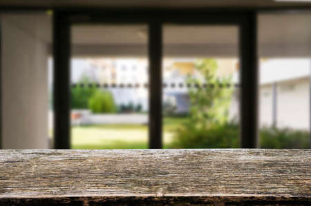 Wooden brown table top against the blurred corridor, passage and courtyard of the house .For product display montage or design is the key visual of the layout.の写真素材