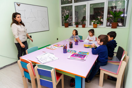 BAKU,AZERBAIJAN-25 MAY 2019 : A young teacher conducts a lesson with her students . Elementary school children sit at their desks and read books in the classroom.のeditorial素材