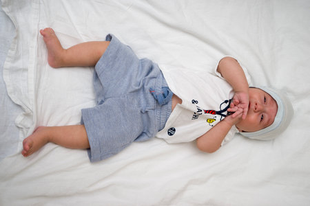 Cute baby lies on a white fluffy backgroundの写真素材