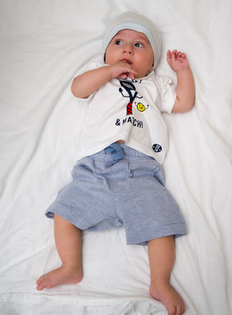 Cute baby lies on a white fluffy backgroundの写真素材