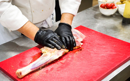 The chef also prepares lamb shank dishes. The process of cooking lamb shank male chef in a professional kitchen. Cooking meat in a Caucasian restaurant.の写真素材
