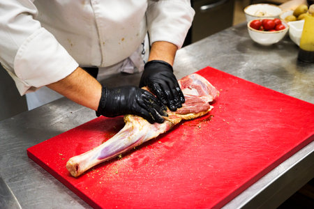 The chef also prepares lamb shank dishes. The process of cooking lamb shank male chef in a professional kitchen. Cooking meat in a Caucasian restaurant.の写真素材