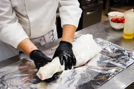 The chef also prepares lamb shank dishes. The process of cooking lamb shank male chef in a professional kitchen. Cooking meat in a Caucasian restaurant.の写真素材