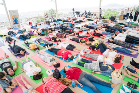 Baku, Azerbaijan-may 10, 2017: the mass of men, women and children meditate yoga in the open airのeditorial素材
