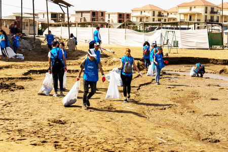 BAKU, AZERBAIJAN- JUNE 20, 2019 : young boys and girls, students clean up garbage on the seashore, on the beach. Environmental protection.のeditorial素材