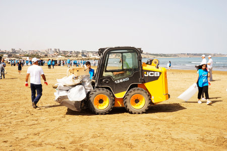 BAKU, AZERBAIJAN- JUNE 20, 2019 : young boys and girls, students clean up garbage on the seashore,...