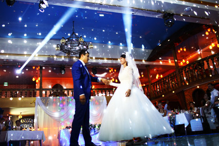 BAKU, AZERBAIJAN - JUNE 28, 2013: Happy bride and groom and their first dance, wedding in an elegant restaurant with wonderful lighting and atmosphere.のeditorial素材